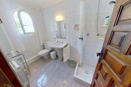 uma casa de banho branca com um lavatório e um WC em Entire home in Jávea-view Montgo em Xàbia