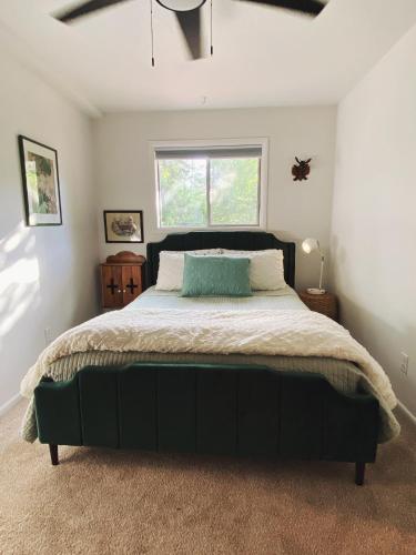 a bedroom with a large black bed with a window at Woods Bay Get-A-Way in Bigfork