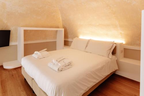a bedroom with a white bed with towels on it at Aeris Suite & Relax in Polignano a Mare