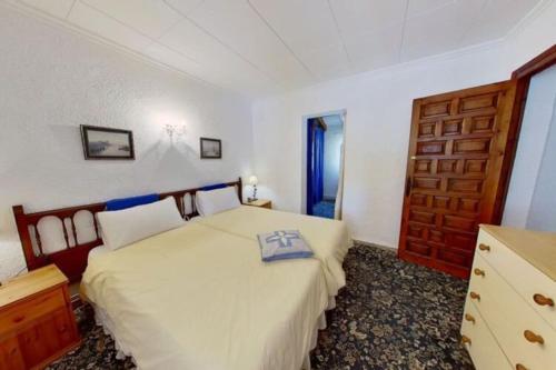 um quarto com uma cama e uma porta de madeira em Entire home in Jávea-view Montgo em Xàbia