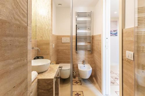 a bathroom with a sink and a toilet and a mirror at Aeris Suite & Relax in Polignano a Mare
