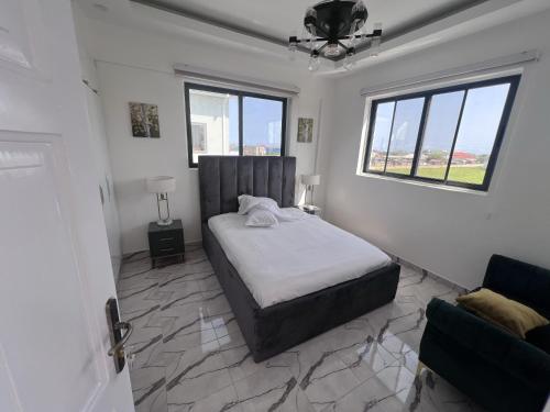 um quarto branco com uma cama e uma janela em Panafest Two Block - 3Fingers em Acra