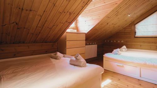 two beds in a attic room with wooden ceilings at Finland House Barcelona- Ideal familias in Argentona