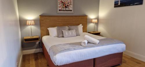 sypialnia z dużym białym łóżkiem z 2 lampami w obiekcie The Cloisters w mieście Dingle