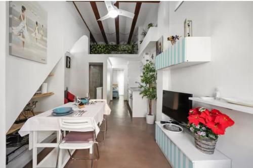 a dining room with a white table and a television at La Casita de la Reina in Valencia