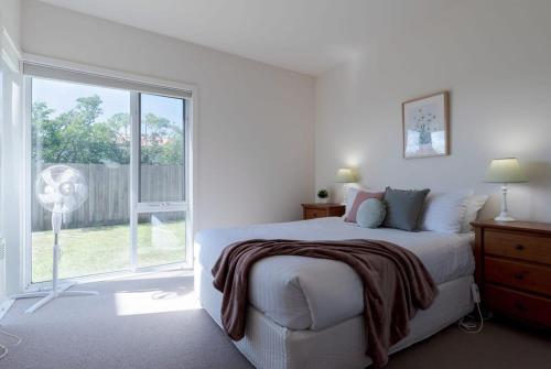 Un dormitorio blanco con una cama y una ventana. en On The Beach & Golf Course Minutes from MTB Trails, en Low Head