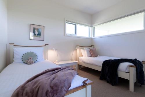 a bedroom with two beds and two windows at On The Beach & Golf Course Minutes from MTB Trails in Low Head