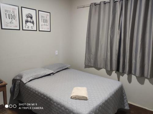 a bedroom with a bed with a towel on it at IDEAL HOTEL in Cascavel