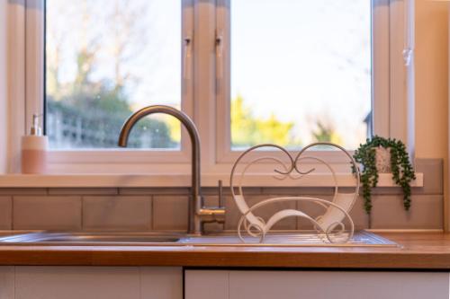 a kitchen sink with a heart holder next to a sink at Bumble Bee Cottage Witney Serviced accommodation in Witney