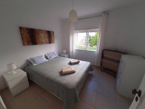 Sonho de férias في بورتيماو: غرفة نوم عليها سرير وفوط