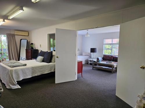 a bedroom with a bed and a living room at MAGNOLIA HOUSE in Featherston