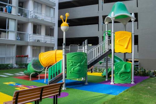 un parque infantil frente a un edificio con tobogán en Amplio iluminado 2 habitaciones, en Barranquilla