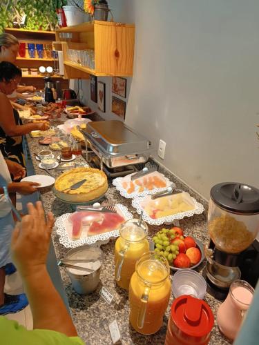a group of people standing in a kitchen preparing food at Pousada Sítio da Floresta in Sana