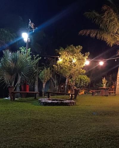 a park at night with a bench and lights at Pousada Sítio da Floresta in Sana