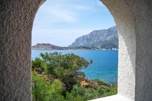 a view of the ocean from a stone window at Pelagos Seafront Accommodation - George in Myrties