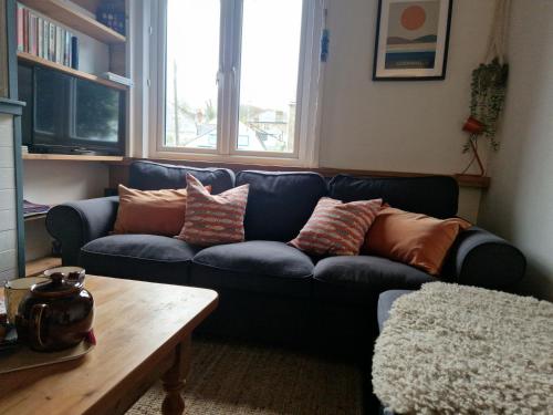 a living room with a blue couch with pillows on it at Victoria Cottage in St. Agnes