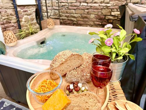 a table with bread and cheese and a hot tub at *Brecon Beacons,Log Burner, hot tub Dogs Welcome* in Crickhowell