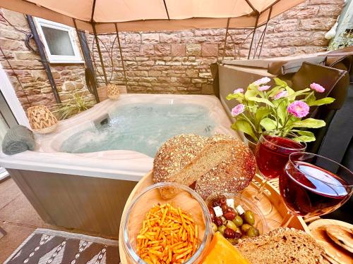 a jacuzzi tub with a bunch of food and bread at *Brecon Beacons,Log Burner, hot tub Dogs Welcome* in Crickhowell
