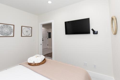 un soggiorno bianco con divano e TV a schermo piatto di The Inn at Fulton a Sandusky