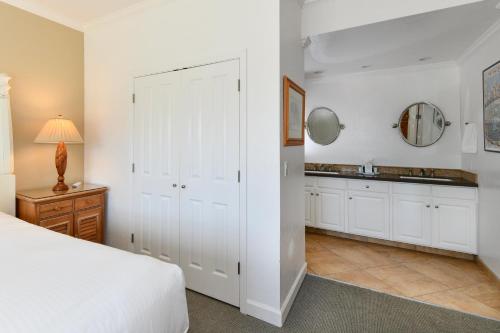 a bedroom with a bed and a sink and a mirror at Charming 2 bd Condo at Silverado in Napa