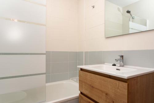 a bathroom with a sink and a tub and a mirror at Apartamento Alborada de Llanes in Posada de Llanes