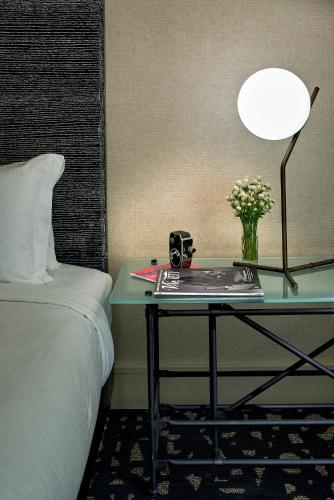 a table with a lamp and a table with a bed at Kimpton Hotel Palomar Los Angeles Beverly Hills by IHG in Los Angeles