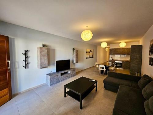 a living room with a couch and a table at Sleeps 6 Spacious Apartment St Pauls Bay in St. Paul's Bay