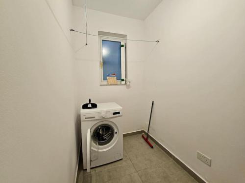 a washing machine in a room with a window at Sleeps 6 Spacious Apartment St Pauls Bay in St. Paul's Bay