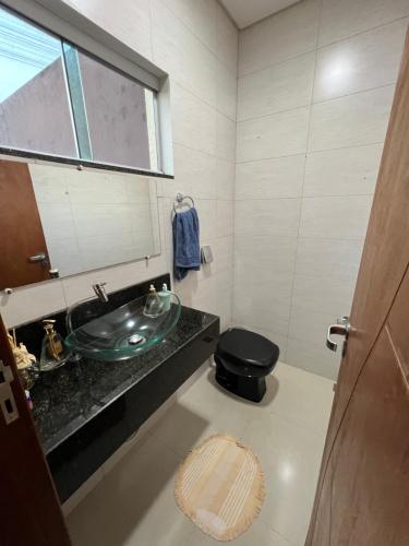 La salle de bains est pourvue d'un lavabo et de toilettes. dans l'établissement Casa Rondônia Rural show!, à Ji-Paraná