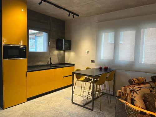una cocina con armarios amarillos y una mesa con sillas en Panorama Europa, en Ávila