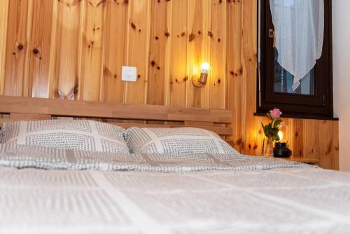 a bedroom with a white bed with a wooden wall at Chalet d'appartement avec une grande terrasse in Torgon