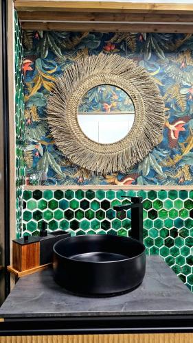 La salle de bains est pourvue d'un miroir et d'un lavabo noir. dans l'établissement Wonderland home, à Granadilla de Abona