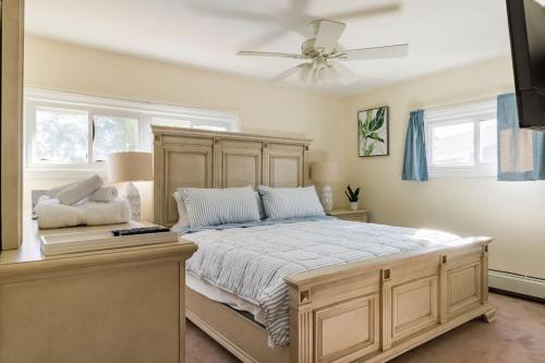 a bedroom with a large bed with a ceiling fan at Private Heated Pool - Sparkling Oasis Near Newport & Navy, 4bd 3ba in Middletown