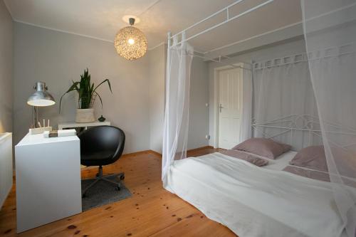 Schlafzimmer mit einem Bett, einem Schreibtisch und einem Stuhl in der Unterkunft Avancers - homelike living in Cottbus