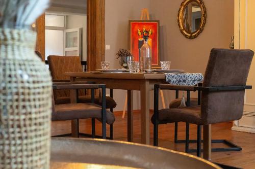 ein Esszimmer mit einem Tisch mit Stühlen und einem Spiegel in der Unterkunft Avancers - homelike living in Cottbus