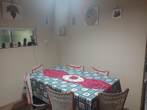 une table à manger avec un tissu de table rouge et blanc dans l'établissement Pousada Maria Rosa, à Blumenau