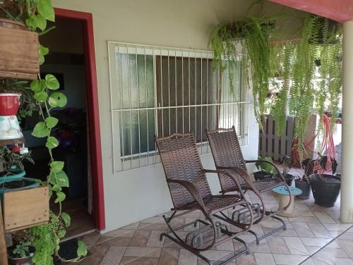 a pair of chairs on a porch with plants at Casa Maria Rosa in Blumenau