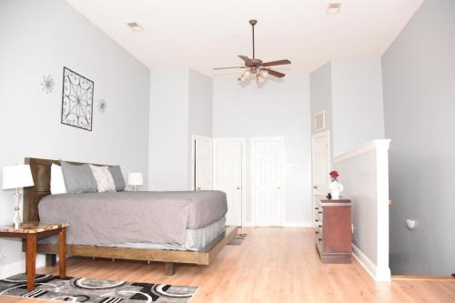 Large Private Room with Balcony and bathroom في تشارلستون: غرفة نوم بها سرير ومروحة سقف