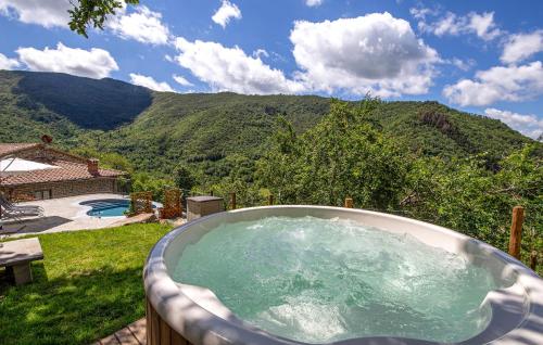 a hot tub with a view of a mountain at Lovely Home In Pian Del Ponte in Serravalle