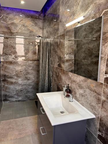 uma casa de banho com um lavatório e um chuveiro em Qawra penthouse 4person AC+wifi em St. Paul's Bay