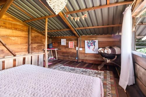 1 dormitorio con 1 cama en una casa de madera en Pachamama, en Salento