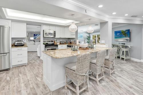 a kitchen with a large island with bar stools at Family Friendly Fort Myers Vacation Rental with Pool in Fort Myers