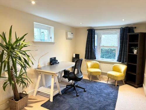 una oficina con escritorio, sillas y una planta en Riverview, en Colchester