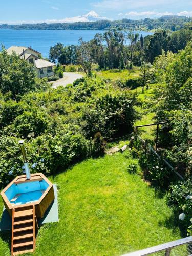 a backyard with a swimming pool in the grass at Espectacular casa Playa Hermosa, lagos y volcanes in Llanquihue