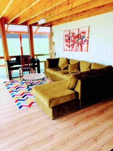 a living room with a couch and a table at Espectacular casa Playa Hermosa, lagos y volcanes in Llanquihue