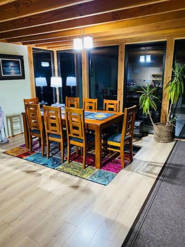 a dining room with a wooden table and chairs at Espectacular casa Playa Hermosa, lagos y volcanes in Llanquihue