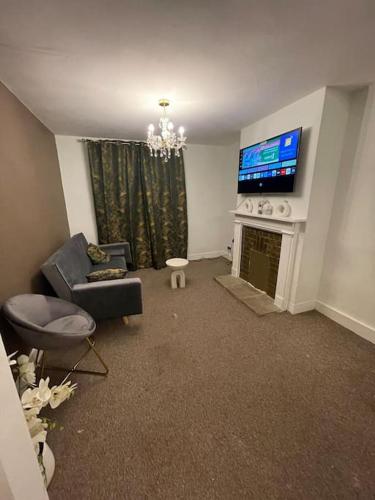Kent的住宿－Modern 2 Bed in the heart of Maidstone，客厅配有电视、沙发和壁炉