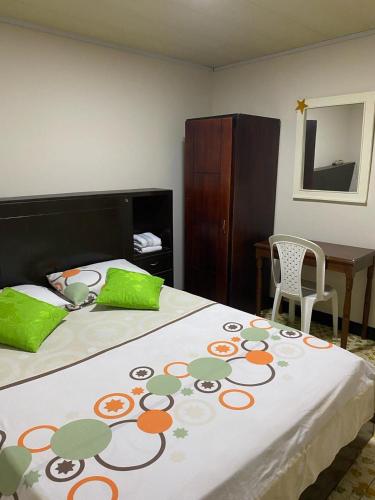 a bedroom with a large bed with green pillows at Hotel La Estrella de la Mañana in Tuluá