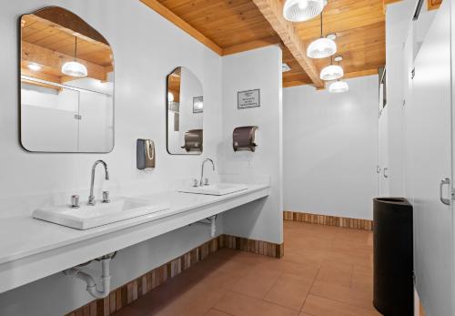 a bathroom with two sinks and two mirrors at Roamstead Smoky Mountains in Cosby