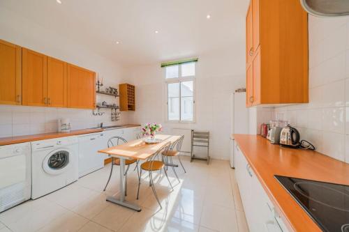 une cuisine avec une table et une machine à laver dans l'établissement Wdf bourgeois 2 bedrooms heart of Cannes!!, à Cannes